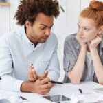 persoană întrebând la bancă despre aplicarea pentru un credit