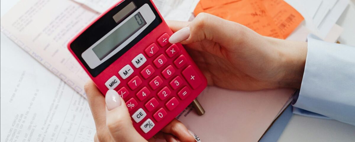 două persoane compară documente financiare și un calculator
