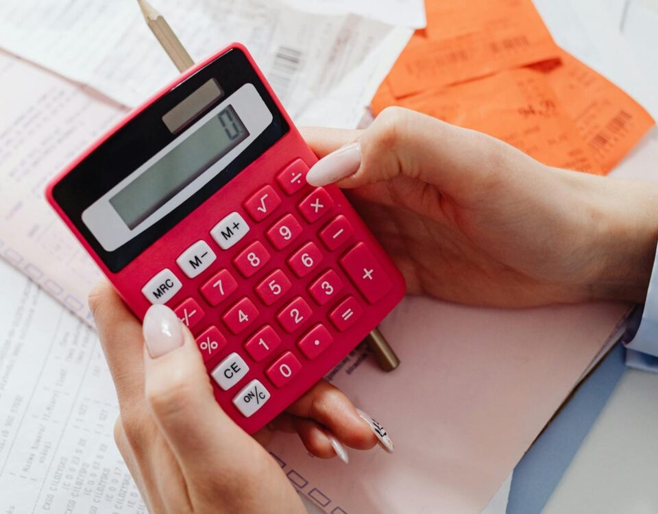 două persoane compară documente financiare și un calculator
