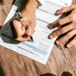 Persoană completând o cerere de credit la bancă