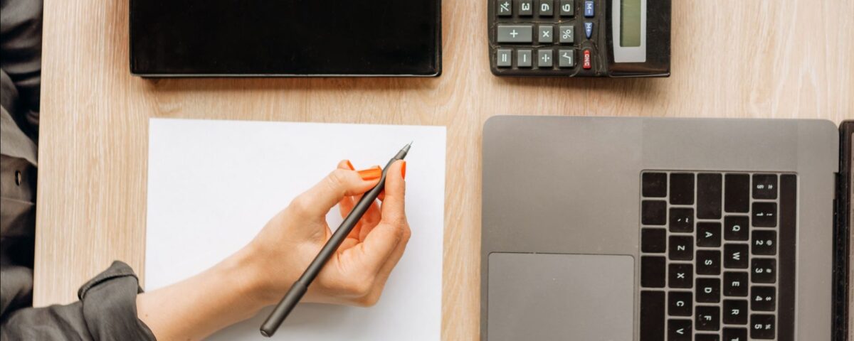 Persoană calculând gradul de îndatorare pe laptop înainte de a aplica pentru credit