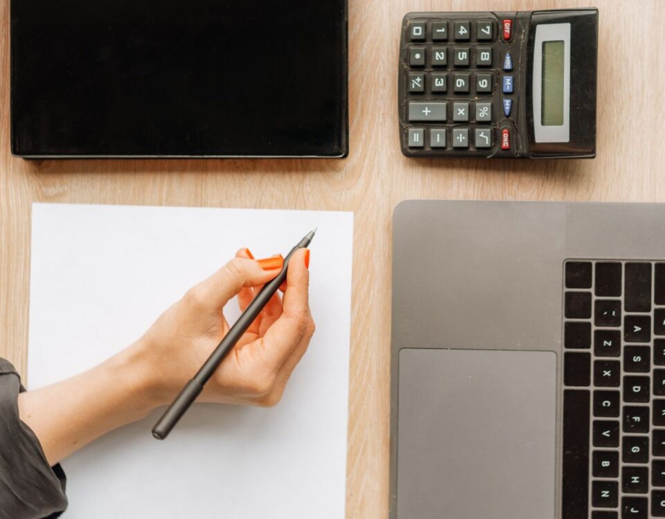 Persoană calculând gradul de îndatorare pe laptop înainte de a aplica pentru credit