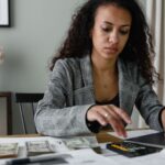 Persoană calculând venituri variabile și bonusuri pentru dosarul de credit bancar