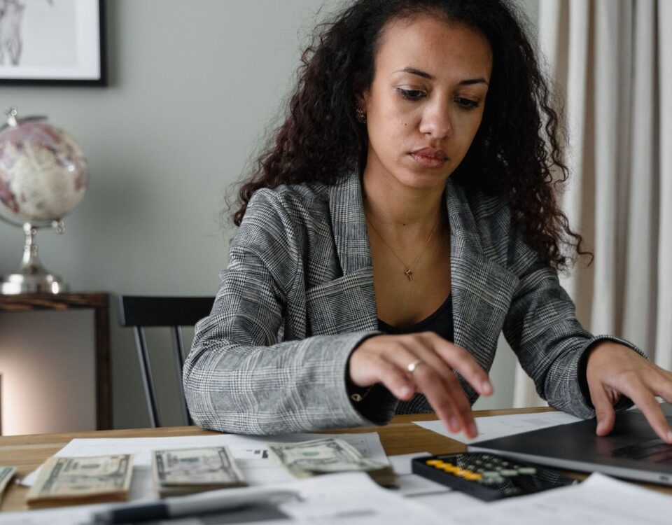 Persoană calculând venituri variabile și bonusuri pentru dosarul de credit bancar