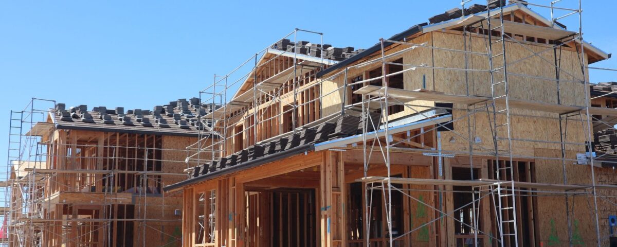 Casă la roșu în construcție lângă o casă finalizată, comparație pentru credit ipotecar