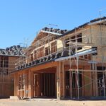 Casă la roșu în construcție lângă o casă finalizată, comparație pentru credit ipotecar