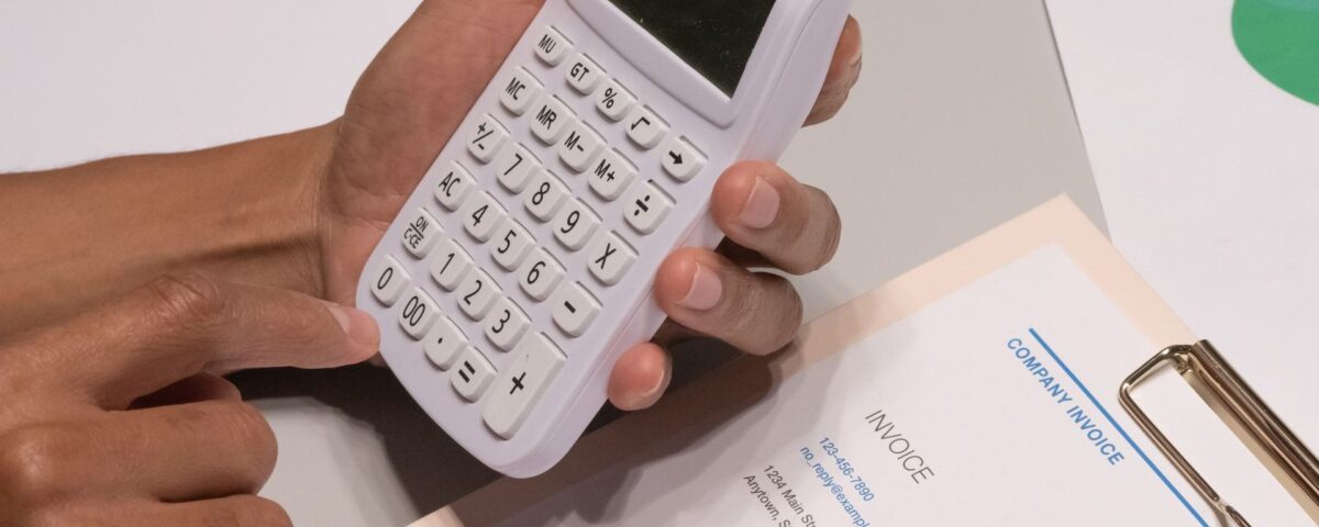 Antreprenor analizând facturi neîncasate și calculator pentru dosarul de credit IMM