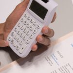 Antreprenor analizând facturi neîncasate și calculator pentru dosarul de credit IMM