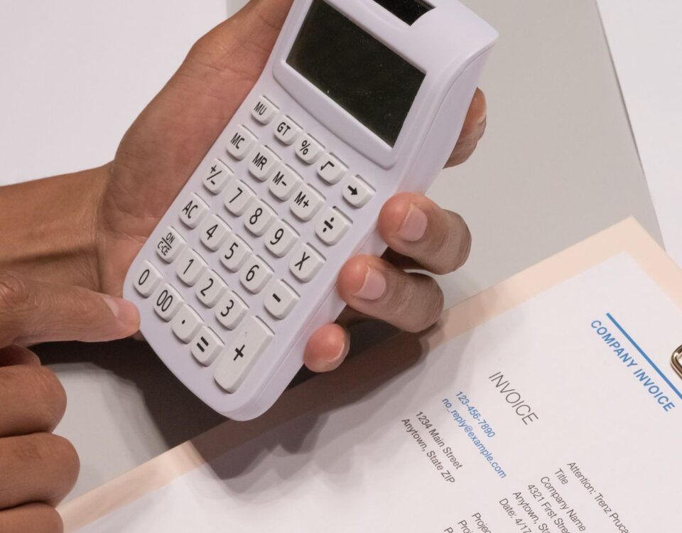 Antreprenor analizând facturi neîncasate și calculator pentru dosarul de credit IMM