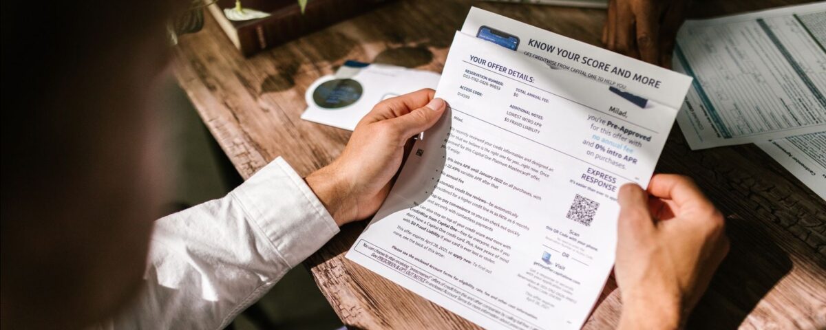 Bărbat analizează documente de credit și calcule de refinanțare acasă