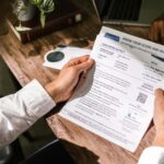 Bărbat analizează documente de credit și calcule de refinanțare acasă