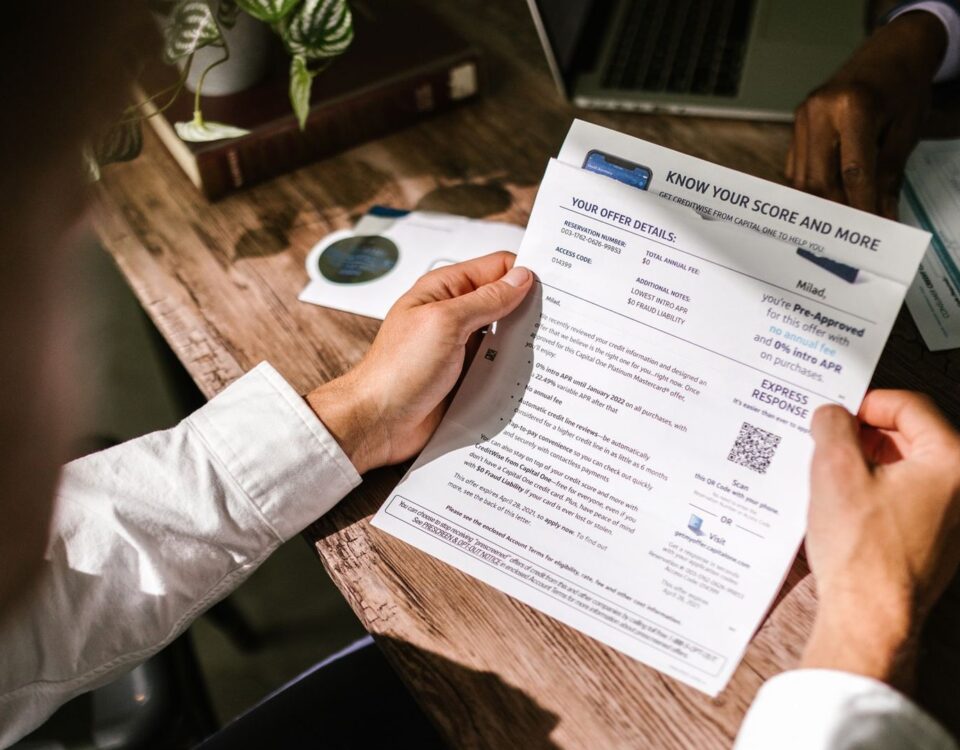 Bărbat analizează documente de credit și calcule de refinanțare acasă