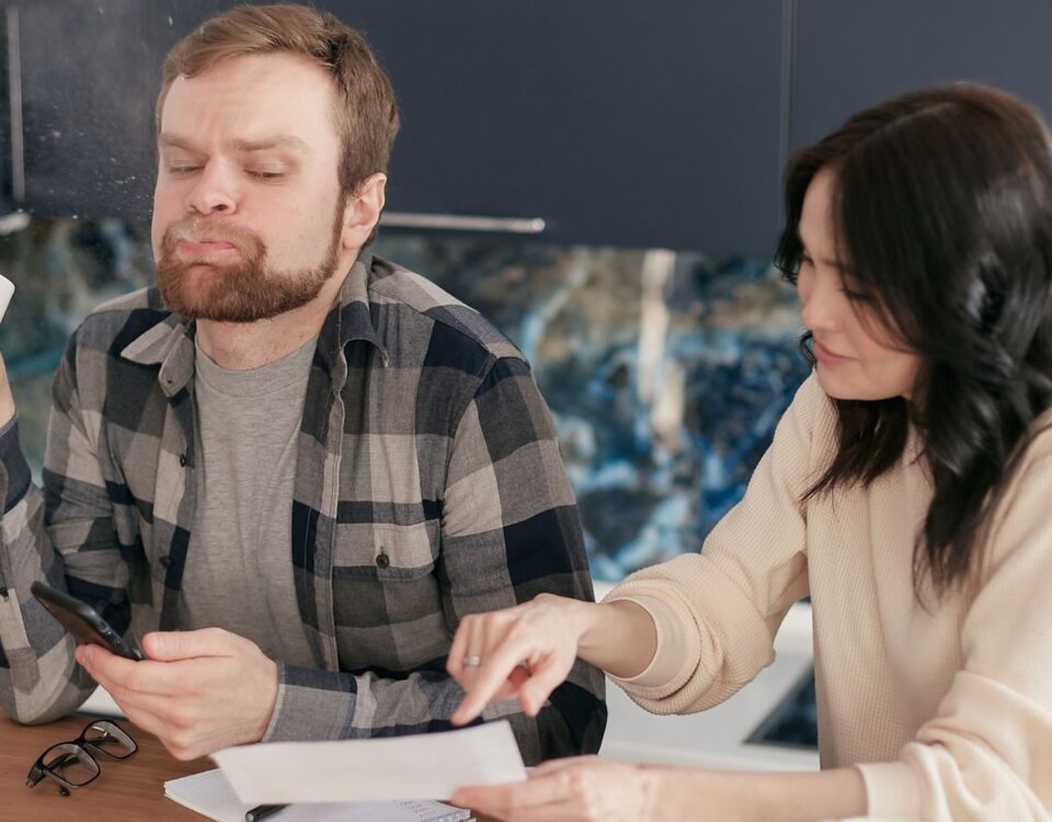 Bărbat calculează rate credit și documente de refinanțare acasă