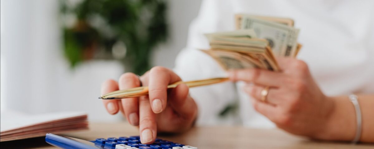 Persoană calculează rate și buget pentru un credit de nevoi personale acasă