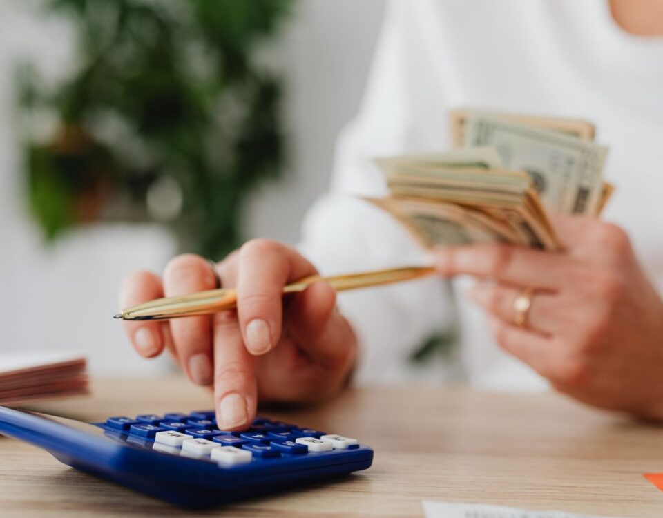 Persoană calculează rate și buget pentru un credit de nevoi personale acasă