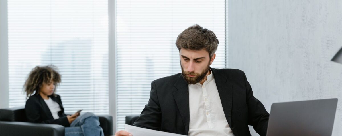 Analist bancar verifică dosarul de refinanțare credit pe calculator