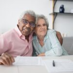 Persoană în vârstă analizează documente de refinanțare credit ipotecar
